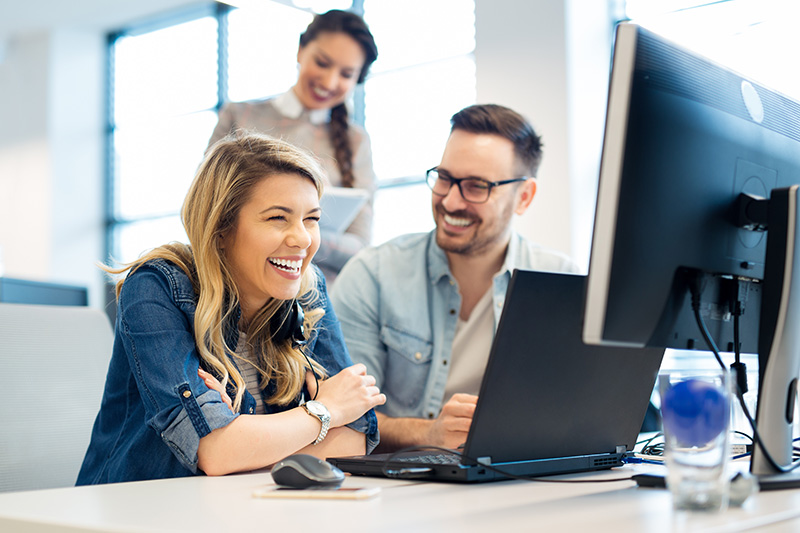 woman laughing while working with team